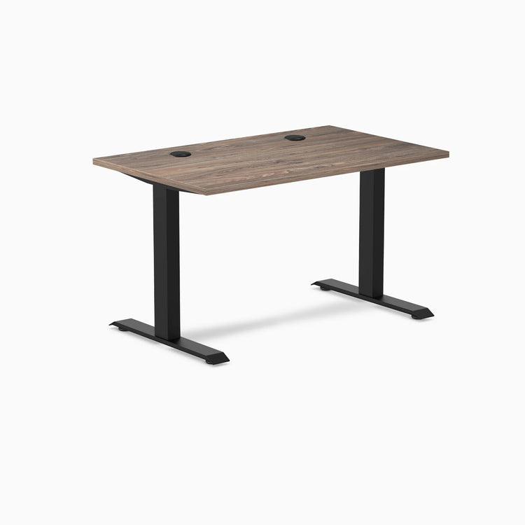 Desky Zero fixed height office desk with natural walnut laminate top, matte black steel frame, and grommets.
