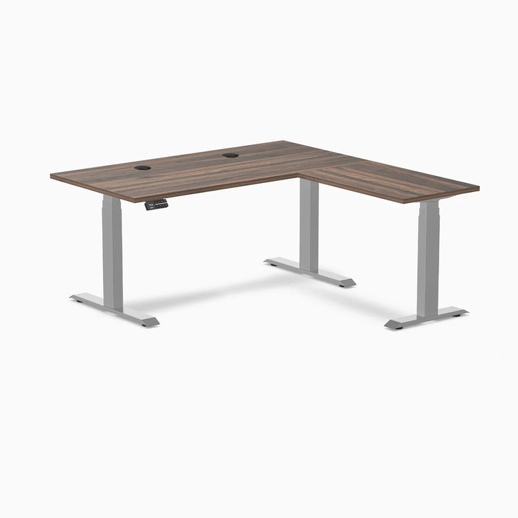 Desky L-Shape Laminate Sit Stand Desk in Jarrah Legno with gray legs and grommets.