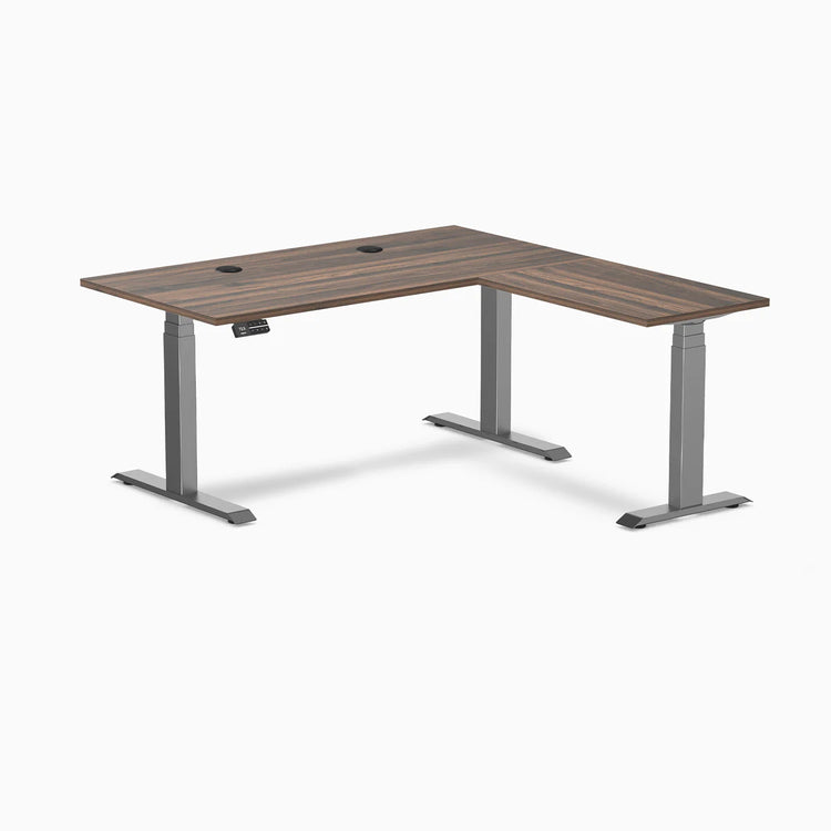 Desky L-Shape Laminate Sit Stand Desk in Jarrah Legno with Space Gray legs and grommets.