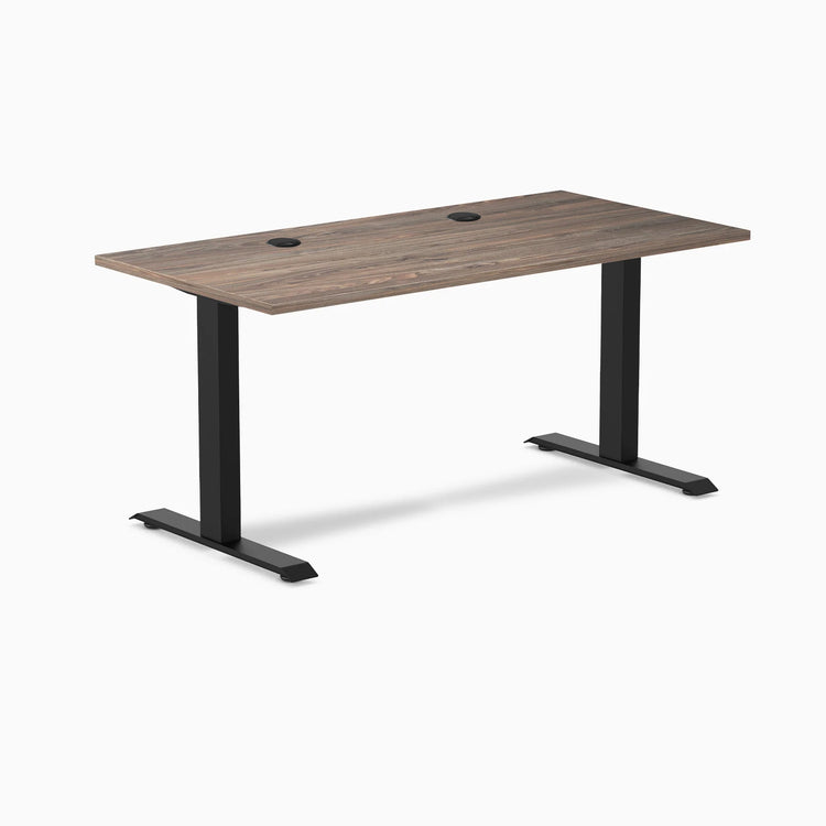 Desky Zero fixed height office desk with natural walnut laminate top, two grommets, and matte black steel frame.