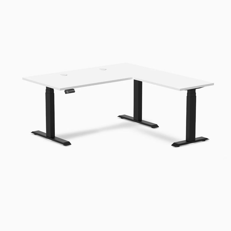 White laminate L-shape sit-stand desk with matte black adjustable legs and grommets.