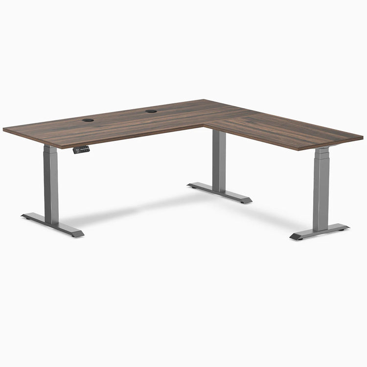 Desky L-Shape Laminate Sit Stand Desk in Jarrah Legno with Space Gray legs and grommets.