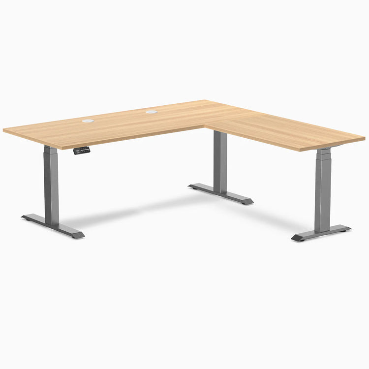 Desky L-Shape Laminate Sit Stand Desk in Sublime Teak with Space Gray frame and grommets.