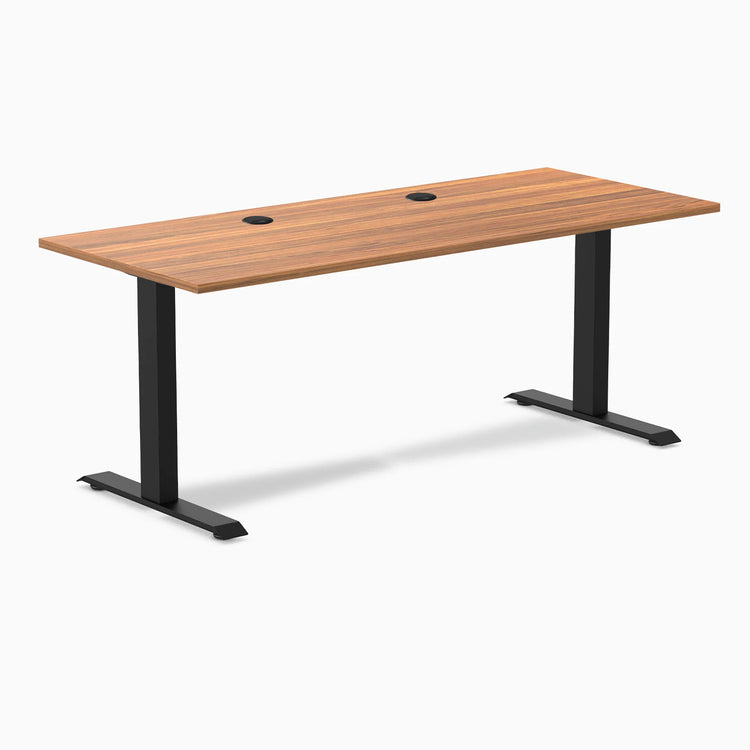 Desky Zero fixed-height office desk with Prime Oak laminate top, two grommets, and matte black steel frame.