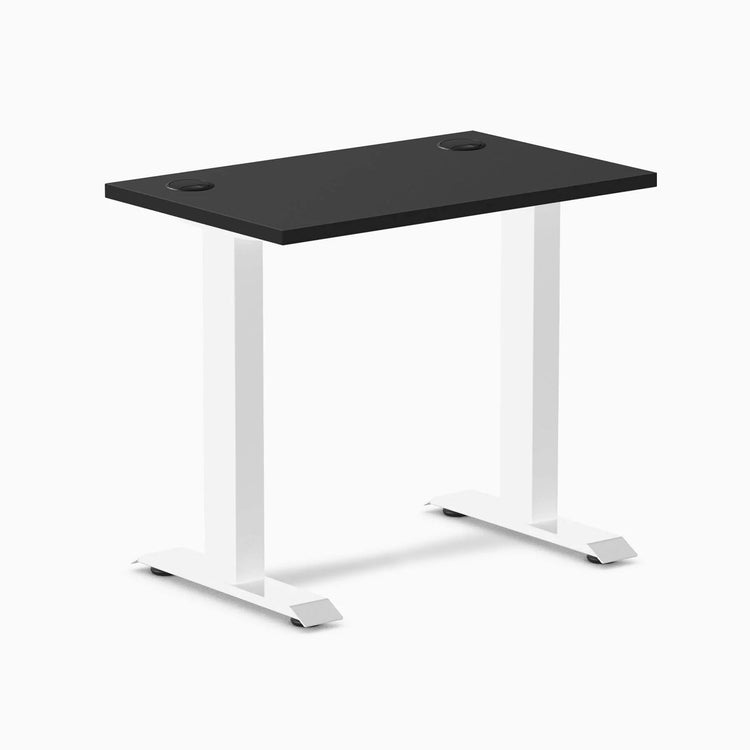 Desky Zero Mini fixed-height desk with black 32x20 inch top, white legs, and grommets.