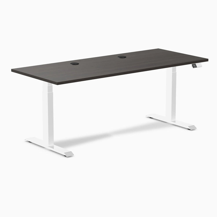 Desky Dual sit-stand desk with burnished wood laminate top, white frame, and two grommets.