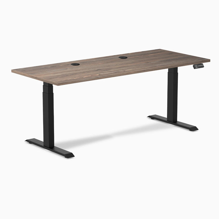 Desky Dual Sit Stand Desk with Natural Walnut laminate top, two grommets, and matte black frame.