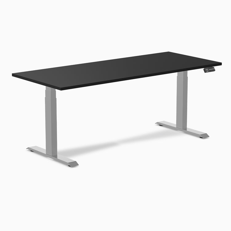 Desky Dual black laminate sit-stand desk with silver adjustable legs and control panel.