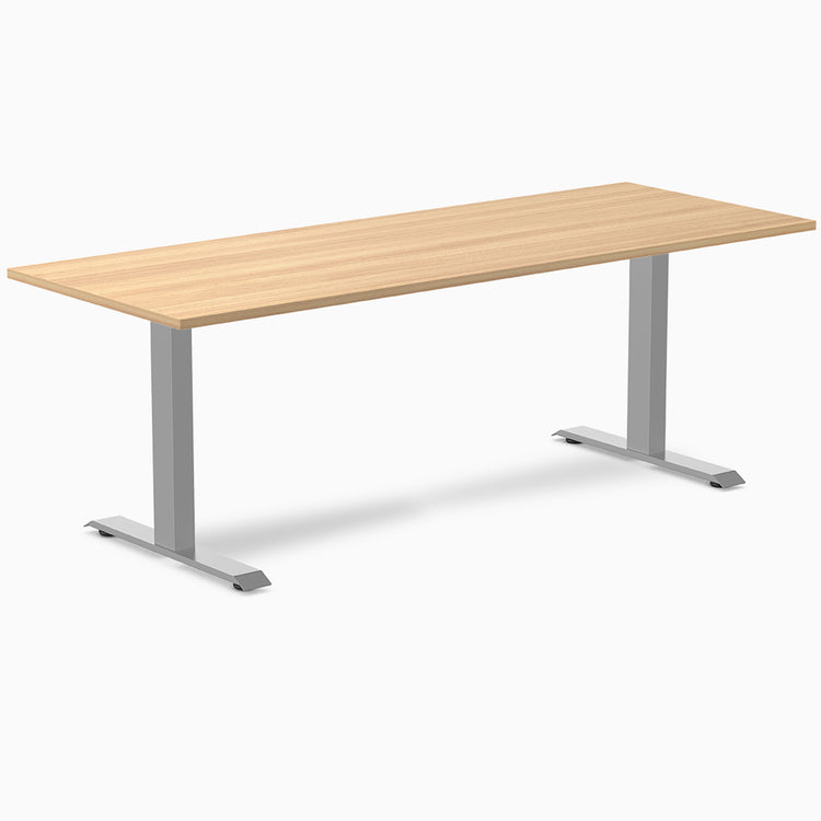 Desky Zero fixed height office desk with a light wood laminate top and silver steel frame.