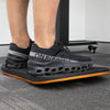 Person standing on a black and orange Desky Balance Board with dimpled footpads.