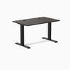 Desky Zero fixed-height office desk with burnished wood laminate top, grommets, and matte black steel frame.
