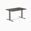 Desky Zero fixed height office desk with burnished wood laminate top, grommets, and space gray steel frame.