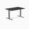 Desky Zero fixed height office desk with black laminate top, grommets, and space gray steel frame.