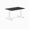 Desky Zero fixed-height office desk with black laminate top, white steel frame, and grommets.
