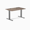 Desky Zero laminate office desk, natural walnut top with grommets, space gray steel frame.