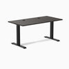 Desky Zero fixed-height office desk with burnished wood laminate top, grommets, and matte black steel frame.