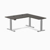 Desky L-Shape Laminate Sit Stand Desk in Burnished Wood with Gray frame and grommets.