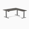 Desky L-Shape Laminate Sit Stand Desk in burnished wood with space gray frame and grommets.