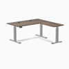 Desky L-Shape Laminate Sit Stand Desk in Jarrah Legno with gray legs and grommets.