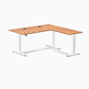 Desky L-Shape Laminate Sit Stand Desk in Prime Oak with white frame and grommets.