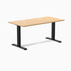 Desky Zero fixed-height office desk with a Sublime Teak laminate top, two grommets, and matte black steel frame.