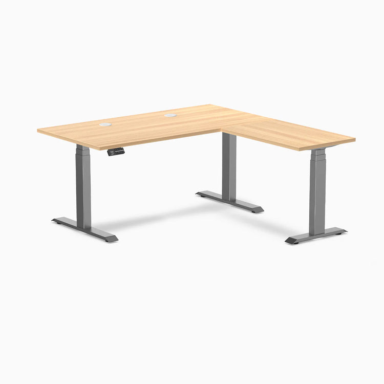 Desky L-Shape Laminate Sit Stand Desk in Sublime Teak with Space Gray frame and grommets.