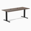Desky Zero fixed-height office desk with Jarrah Legno laminate top, black steel frame, and two grommets.