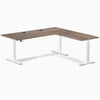 Desky L-Shape Laminate Sit Stand Desk in Natural Walnut with white frame and grommets.