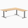 Desky L-Shape Laminate Sit Stand Desk in Sublime Teak with Space Gray frame and grommets.