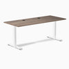 Desky Zero laminate office desk with natural walnut top, white steel frame, and two grommets.