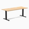 Desky Zero fixed height office desk with Sublime Teak laminate top, 70.9x29.5 inches, grommets, and matte black steel frame.