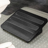 Black Desky Classic Foot Rest with three textured non-skid panels, on a clear mat over dark carpet.