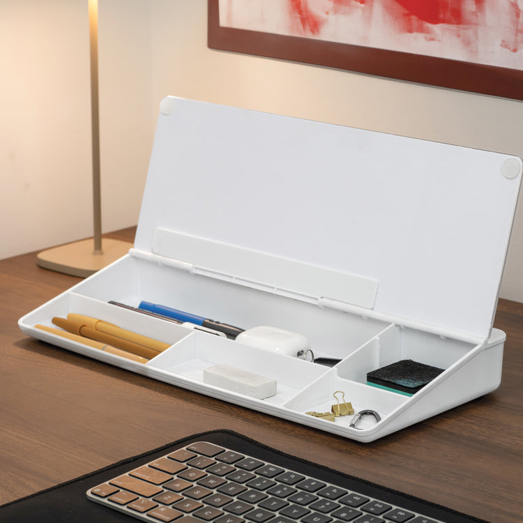 White Desky Desktop Whiteboard with open lid, showing organized compartments holding pens, eraser, keys, and an earbud case on a wooden desk.