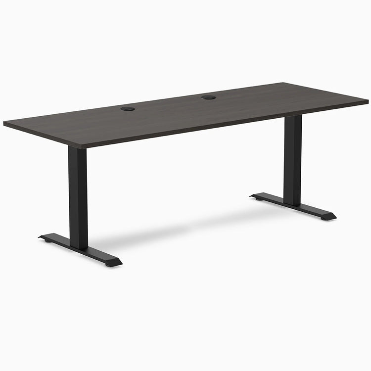 Desky Zero fixed height office desk with burnished wood laminate top, two grommets, and matte black steel frame.