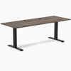 Desky Zero fixed-height office desk with Jarrah Legno laminate top, black steel frame, and two grommets.