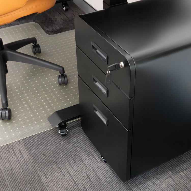 Black steel Desky 3-drawer mobile filing cabinet with rounded edges, key in lock, next to an office chair.