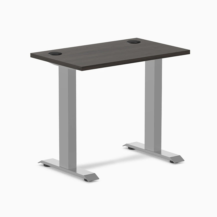 Desky Zero Mini fixed-height desk with burnished wood top, gray frame, and two grommets.