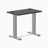 Desky Zero Mini fixed-height desk with burnished wood top, gray frame, and two grommets.