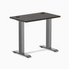 Desky Zero Mini sit-stand desk, burnished wood top with grommets, space gray legs.