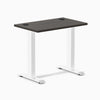 Desky Zero Mini fixed-height desk with burnished wood top, white legs, and two grommets.