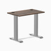 Desky Zero Mini desk with Jarrah Legno top, gray fixed-height legs, and two grommets.