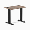Desky Zero Mini fixed-height desk with natural walnut top, black legs, and two grommets.