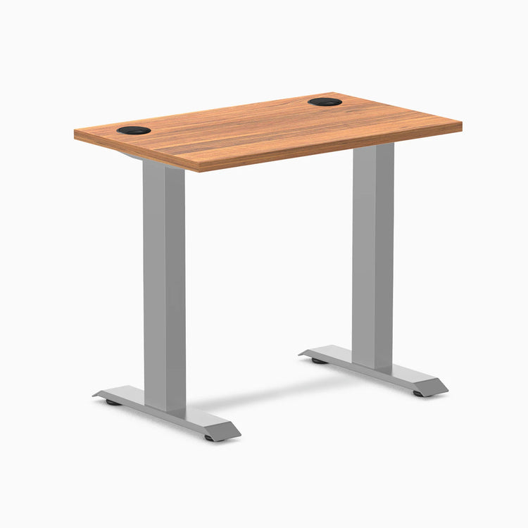 Desky Zero Mini fixed-height desk with Prime Oak 32x20 inch top, gray legs, and two black grommets.
