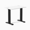 Desky Zero Mini fixed-height desk with a white 32x20 inch top, matte black legs, and grommets.