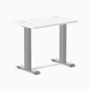 Desky Zero Mini fixed-height desk with white top, gray legs, and two grommets.
