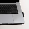 Silver laptop securely held by a black Desky Expandable Laptop Mount with silicone pads.