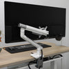 White Desky Single Slim Aluminium Monitor Arm with a subtle, slimline design, clamped to a light wood desk.