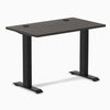 Desky Zero Mini sit-stand desk with burnished wood top, 40x24 inches, grommets, and matte black legs.