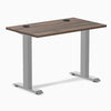 Desky Zero Mini fixed-height desk with Jarrah Legno top, gray legs, and two grommets.