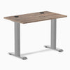 Desky Zero Mini fixed-height desk with natural walnut top, gray legs, and two grommets.